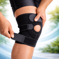 Person adjusting a black knee brace with a blurred natural background